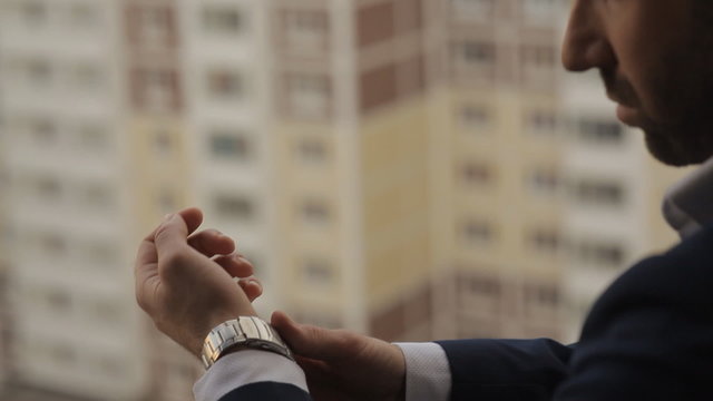 A man puts into the hands of the clock
