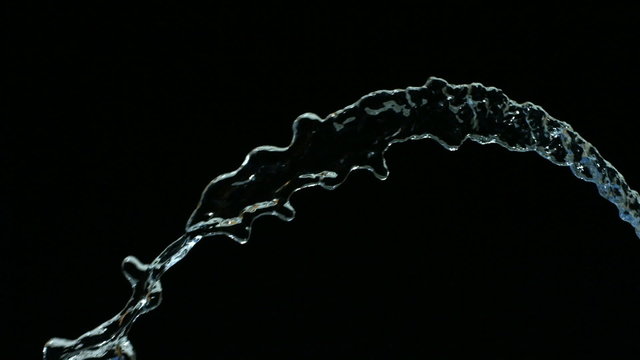 Water flow on black background, slow motion