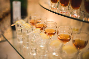 Different alcohol drinks in goblets and wine glasses on wedding buffet table