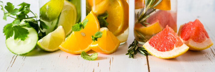 Selection of infused water in glass bottles, rustic wood background