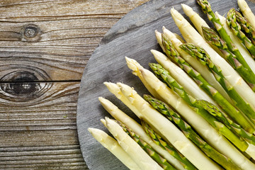 Organic fresh green and white asparagus on wooden table