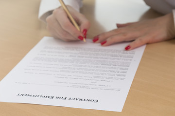 Unrecognizable woman signing employment contract 