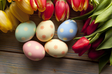 Obraz na płótnie Canvas Easter eggs and flowers on wooden background