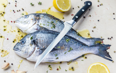 Fresh dorada fishe and a knife
