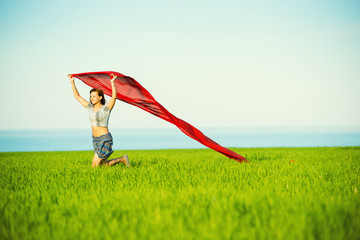 Young happy woman in wheat field with fabric. Summer lifestyle