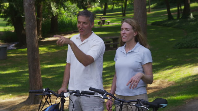 Mature couple talking and planning bicycle route