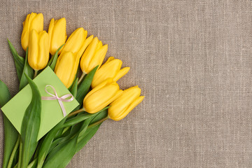 Mothers Day background. Tulips, note on sackcloth