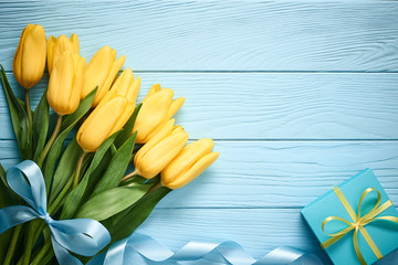 Mothers Day background. Tulips, gift box on wood