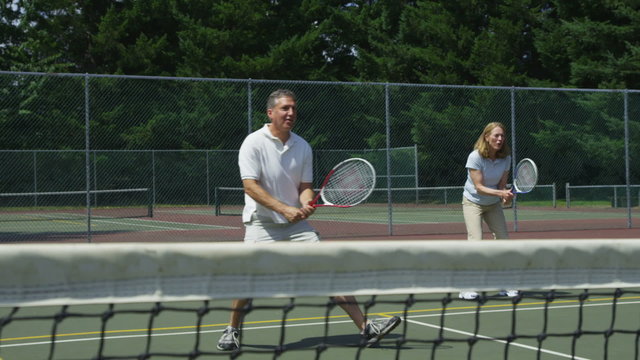 Mature couple playing tennis