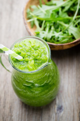 Rucola smoothie, on the grey  background.