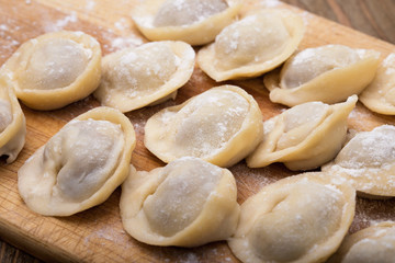 Fototapeta na wymiar Homemade meat dumplings on a wooden board close-up