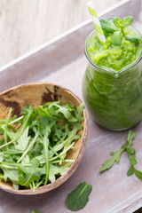 Rucola smoothie, on the grey  background.