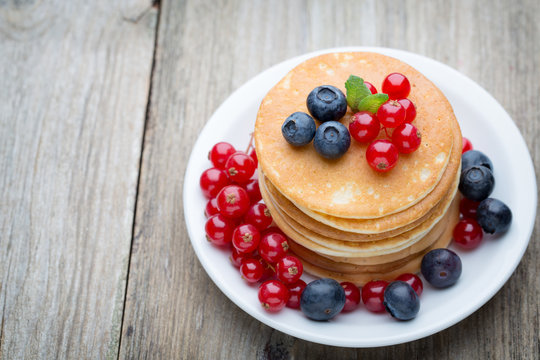 Stack of pancakes with blueberry and fresh berry.
