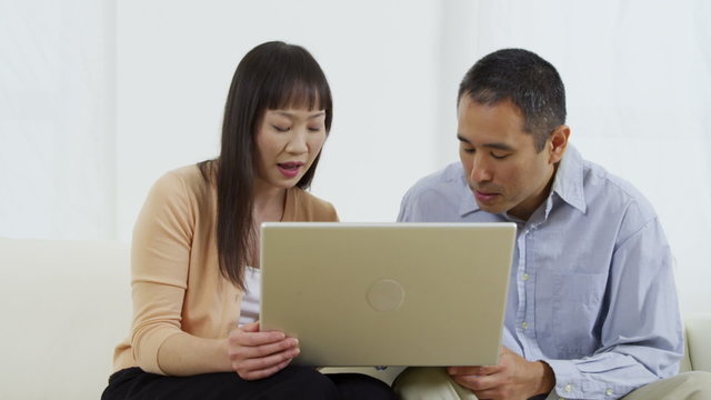 Asian couple using laptop computer together