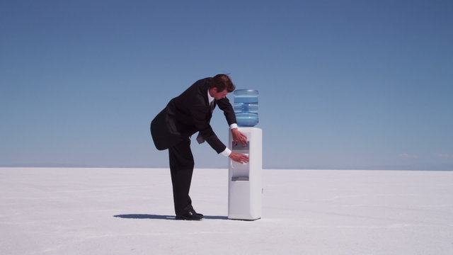 Businesspeople in desert drink at water cooler