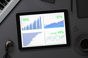 Top view of digital tablet with financial statistics on a black