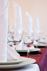 Table in a restaurant with glasses, napkins and plates