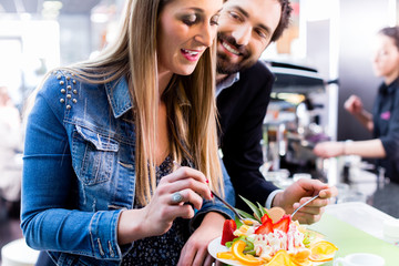 Woman eating fruit sundae in ice cream cafe