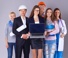 Smiling businesswoman with laptop  and group of industrial workers