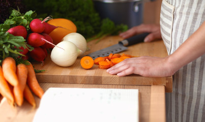 Young woman cutting vegetables in the kitchen