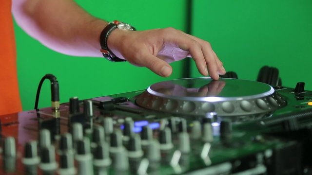 Dj adjusts the tempo on the mixing panel.