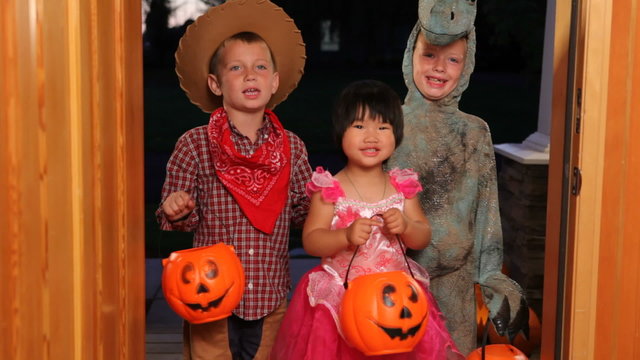 Three children in Halloween costumes trick or treating