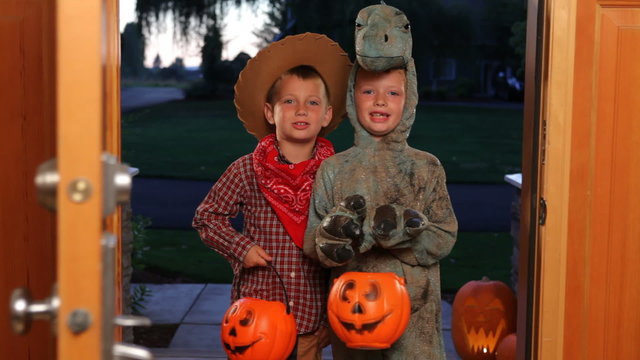 Two children in Halloween costumes trick or treating