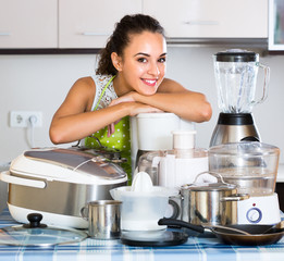 Girl with kitchen appliances at home.