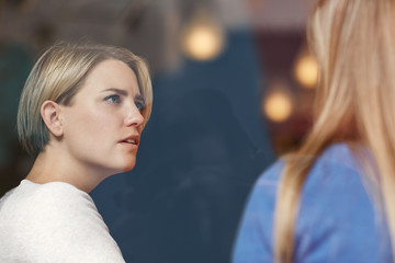 Woman looking concerned while listening carefully to her friend