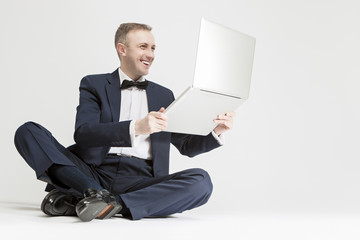 Young Smiling Caucasian Blond Man Holding  Laptop and Smiling