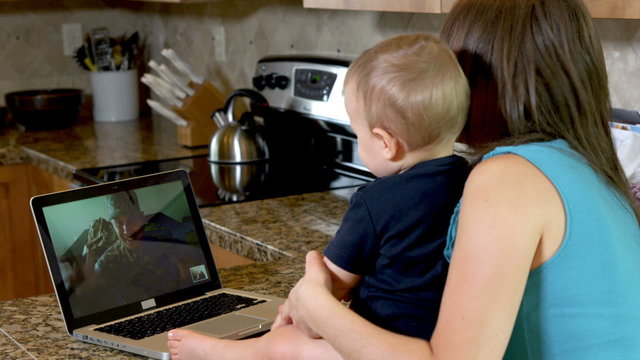 Mother and baby video chat with military father