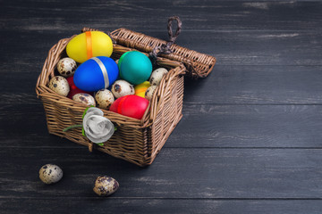 Wicker basket with colored chest chicken and quail eggs