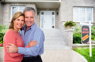 Happy senior couple near new house.