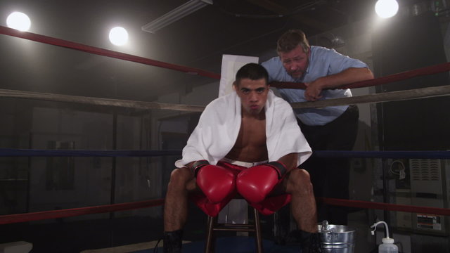 Boxer sitting in corner of ring preparing for fight