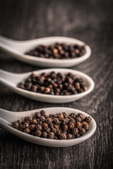 Peppercorns on white spoons