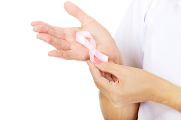 Elderly female doctor or nurse holds pink breast cancer awareness ribbon
