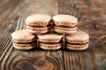 Chocolate macaroons and black chocolate on old wooden table