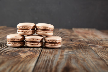 Chocolate macaroons and black chocolate on old wooden table