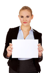 Fototapeta premium Smiling young businesswoman holding blank banner