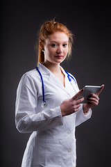 redheaded doctor holding a tablet