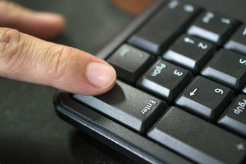 Obraz premium Fingers pressing enter key