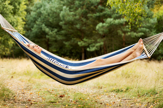 Young blonde woman resting on hammock