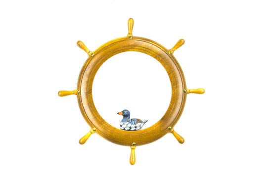 Isolated ship steering wheels art frame with wooden bird toy
