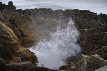 The main blowhole at Punakaiki on the West Coast of New Zealand, named Pluto, erupts with a gush of...