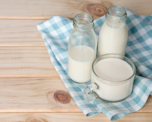 Obraz na płótnie Canvas Milk bottle and milk glass put on wooden.