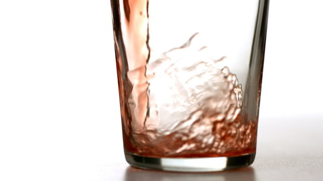 Cranberry juice pouring into glass, slow motion
