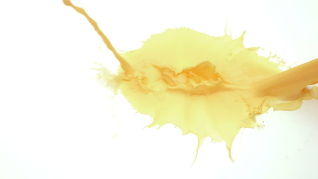Yellow splatters on white background, slow motion
