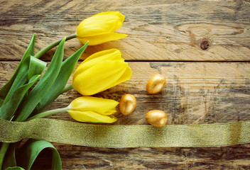 Easter background with tulips, three golden eggs