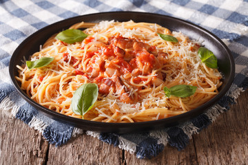 Italian food: pasta with Amatriciana Sauce  and basil close-up. horizontal
