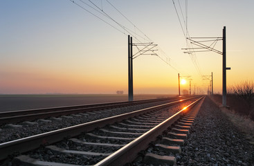 Fototapeta na wymiar Railroad - Railway at sunset with sun